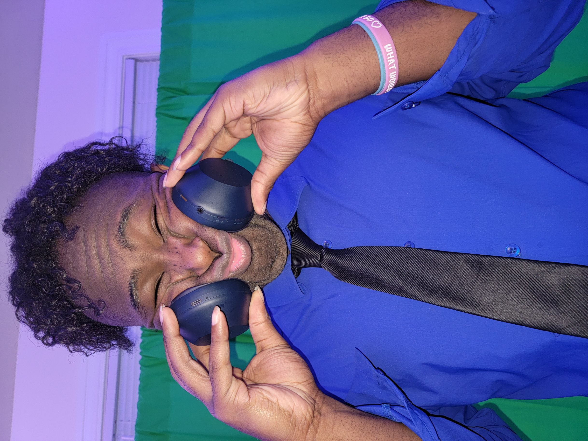 Semi-Formal Photo-Portrait of Shakuryon Steward with him squisihing his face with studio headphones
